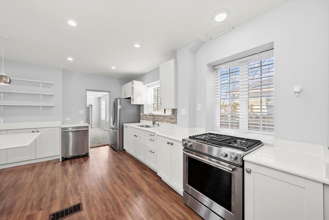 kitchen with stainless steel appliances, a sink, visible vents, white cabinets, and light countertops