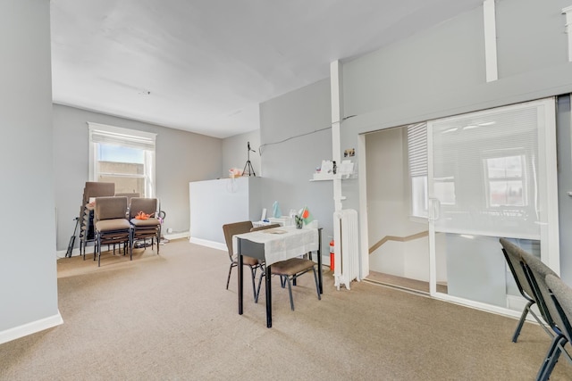 dining room featuring carpet floors, radiator heating unit, and baseboards