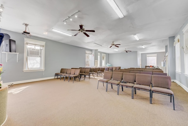 interior space featuring ceiling fan, carpet floors, rail lighting, and baseboards