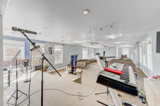 game room with baseboards, a ceiling fan, and light colored carpet