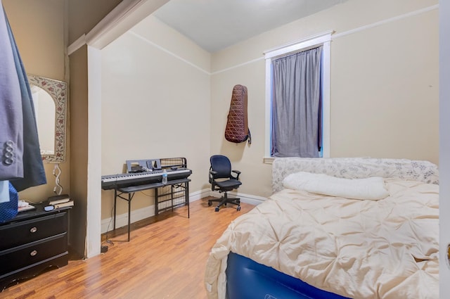 bedroom featuring baseboards and wood finished floors