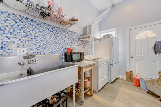 kitchen featuring white range oven, light countertops, light wood-type flooring, wall chimney range hood, and black microwave