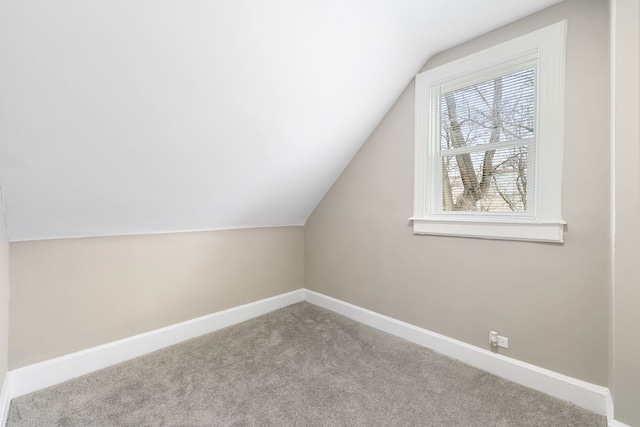 bonus room with light carpet, lofted ceiling, and baseboards