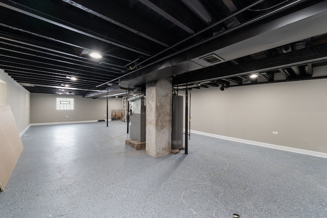 basement featuring water heater, visible vents, and baseboards