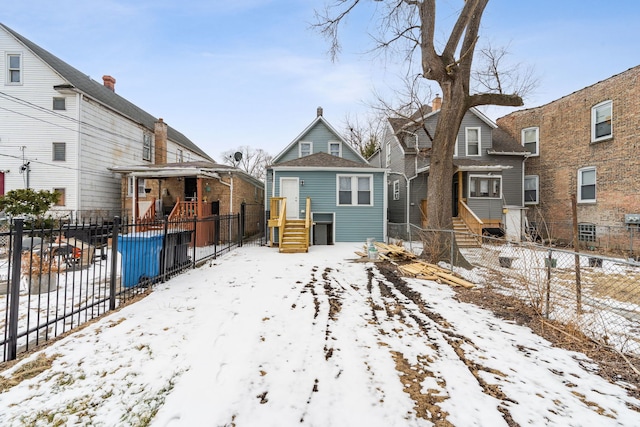 snow covered property featuring fence and a residential view