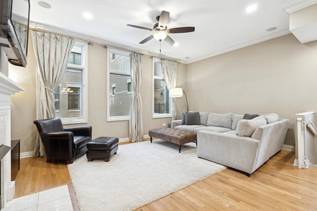 living room with a wealth of natural light, crown molding, baseboards, and wood finished floors