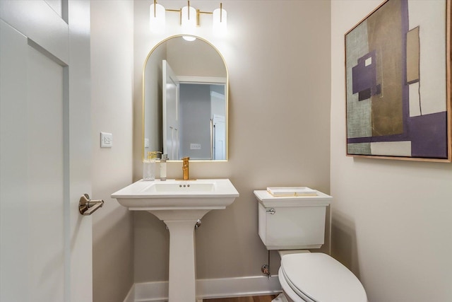 bathroom featuring toilet and baseboards