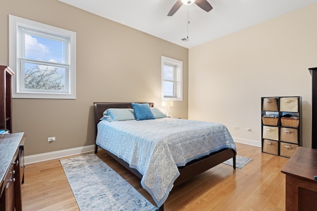 bedroom featuring light wood-type flooring, visible vents, ceiling fan, and baseboards