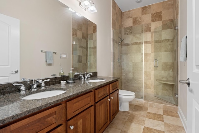 full bath with double vanity, a sink, toilet, and a shower stall