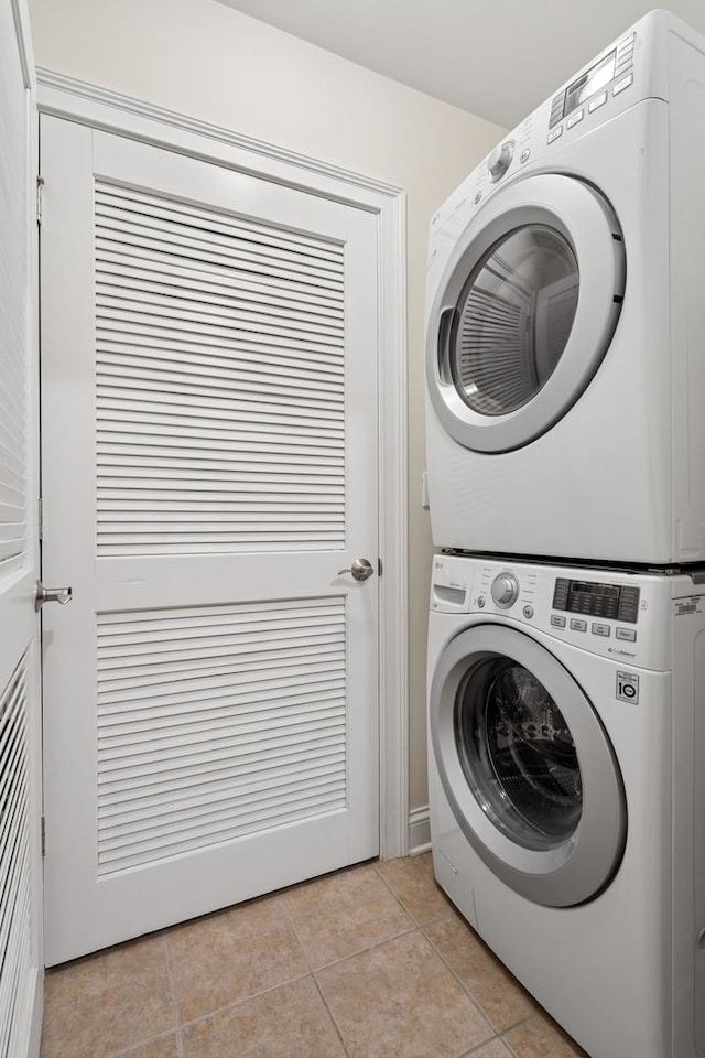 washroom with laundry area, light tile patterned floors, and stacked washer / drying machine