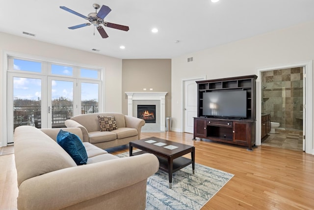 living room with ceiling fan, recessed lighting, visible vents, light wood-style floors, and a glass covered fireplace