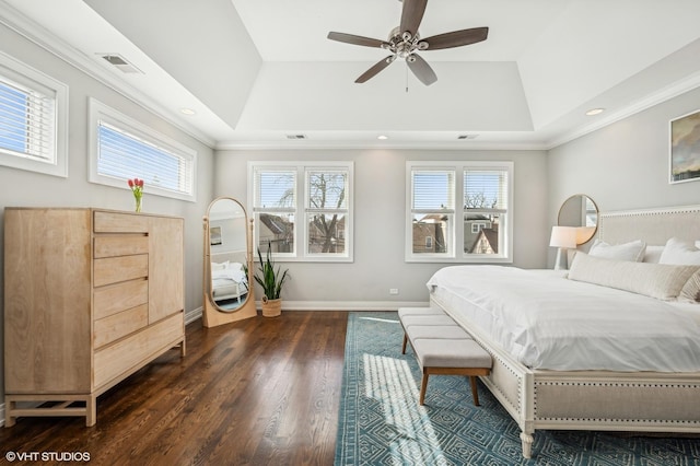 bedroom featuring dark wood-style floors, multiple windows, visible vents, and a raised ceiling