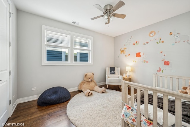 bedroom featuring visible vents, baseboards, and wood finished floors