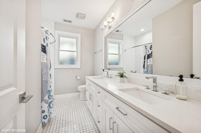 full bathroom with a healthy amount of sunlight, visible vents, and a sink