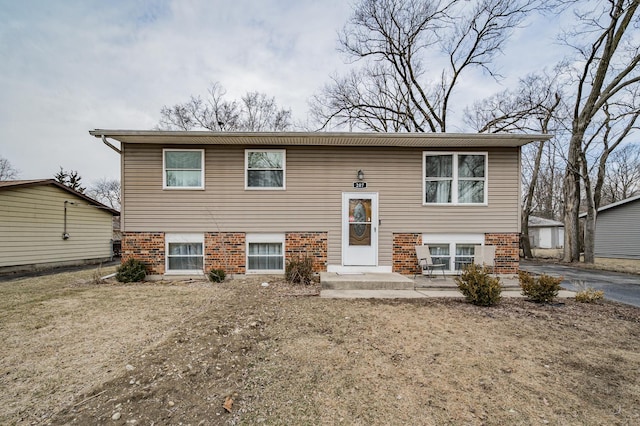 bi-level home with a patio and brick siding