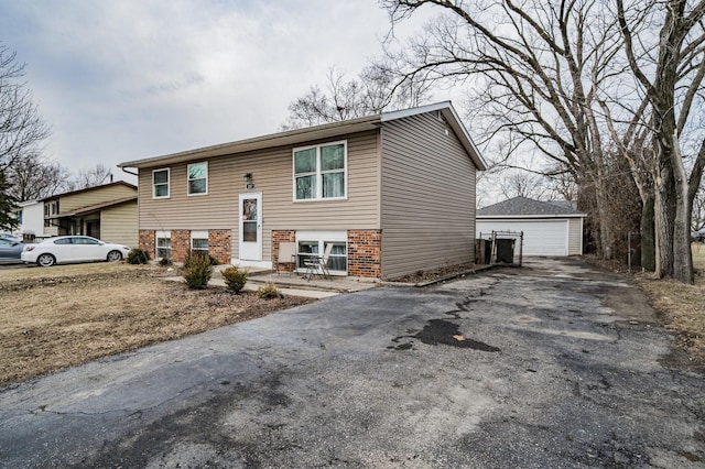 raised ranch with a garage, brick siding, and an outdoor structure