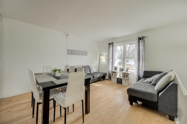 dining space featuring light wood finished floors and baseboards