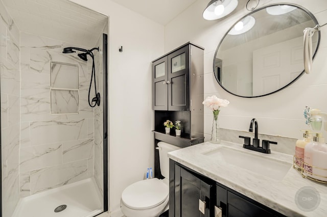 full bath with toilet, vanity, and a marble finish shower