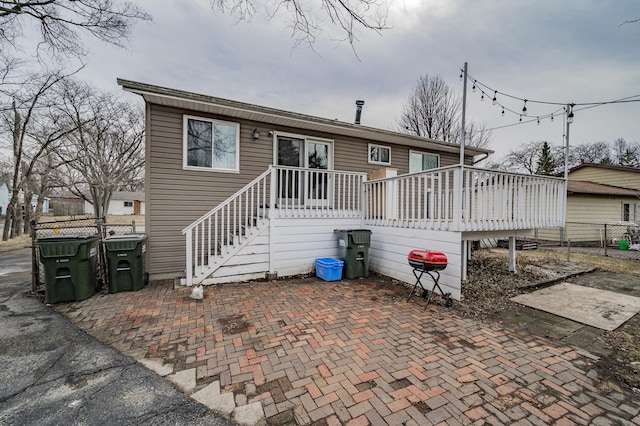 view of front of property with a patio, fence, and a wooden deck