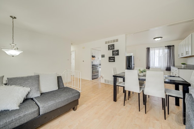 dining room with light wood-style flooring and visible vents