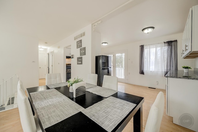 dining space featuring visible vents and light wood-style floors