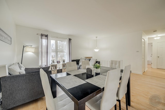 dining area featuring light wood-style flooring and baseboards