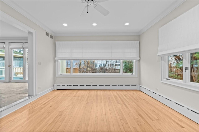 unfurnished living room featuring ornamental molding, a baseboard radiator, wood finished floors, and a wealth of natural light