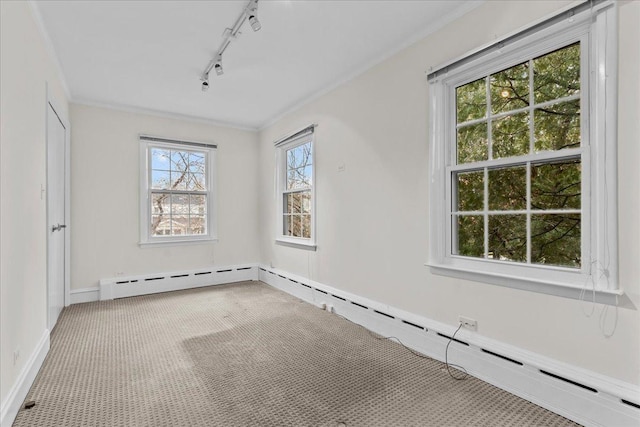 unfurnished room with rail lighting, carpet, ornamental molding, and baseboard heating