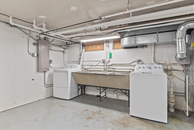 unfinished basement with washing machine and dryer, electric panel, and a sink