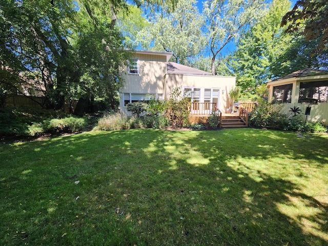 back of property featuring a lawn and a wooden deck