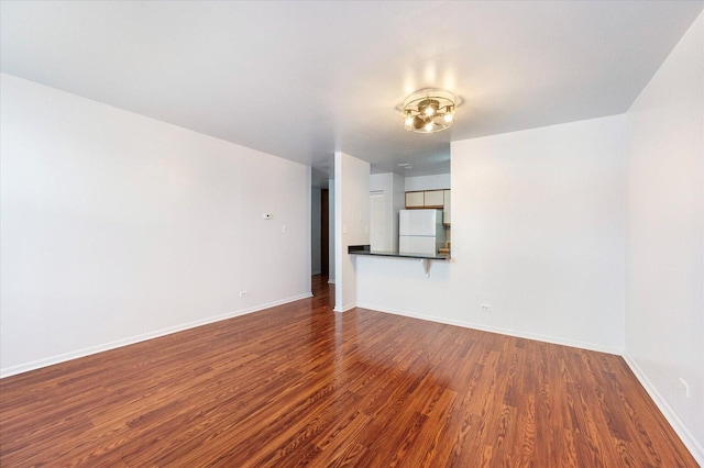 empty room with dark wood-style floors and baseboards