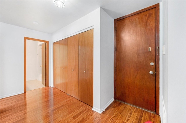 corridor with light wood finished floors and baseboards