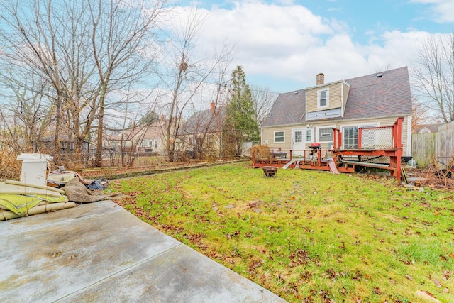 view of yard featuring a fire pit, a deck, a patio area, and fence