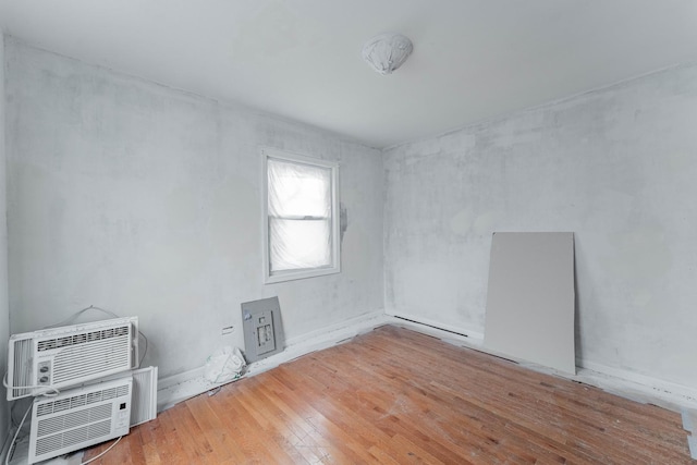 empty room with a wall mounted air conditioner and wood finished floors