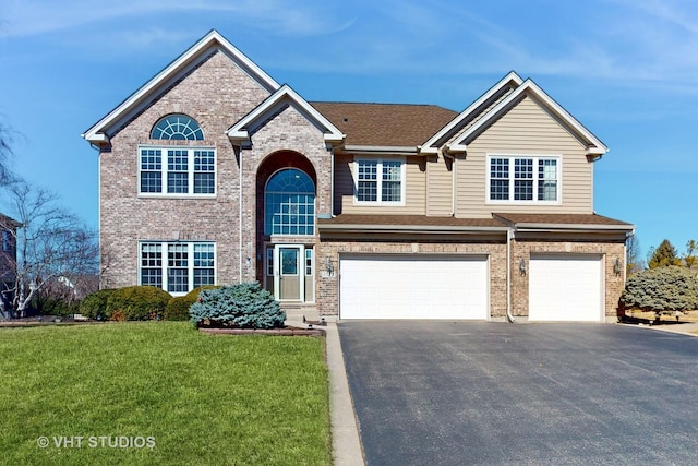 traditional-style house featuring a garage, driveway, brick siding, and a front lawn