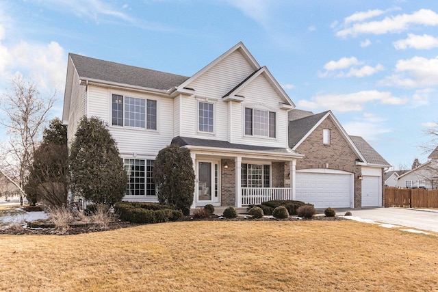 traditional-style house with covered porch, brick siding, concrete driveway, roof with shingles, and a front lawn