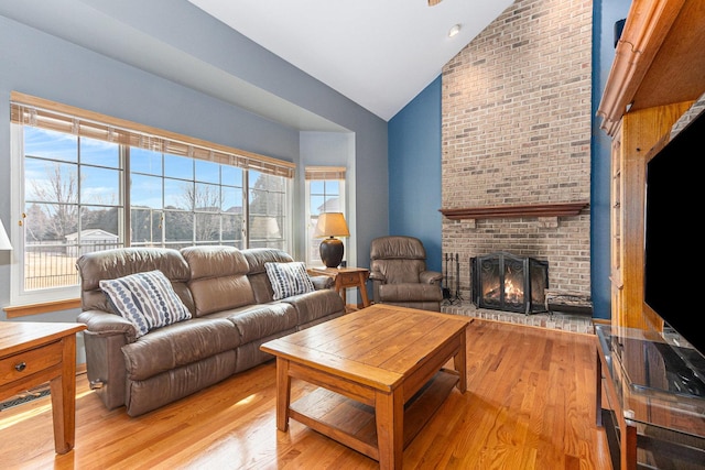 living room with light wood-style flooring, a fireplace, and a wealth of natural light