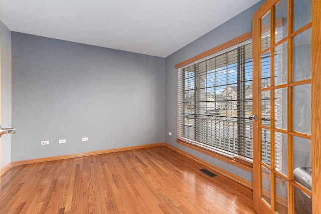 empty room with baseboards, visible vents, and light wood-style floors