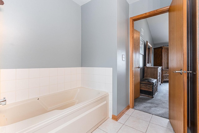 ensuite bathroom featuring a garden tub, baseboards, connected bathroom, and tile patterned floors