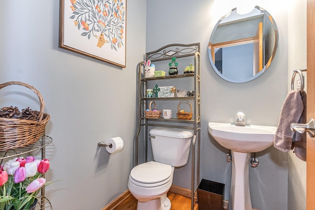 bathroom featuring toilet, baseboards, and wood finished floors