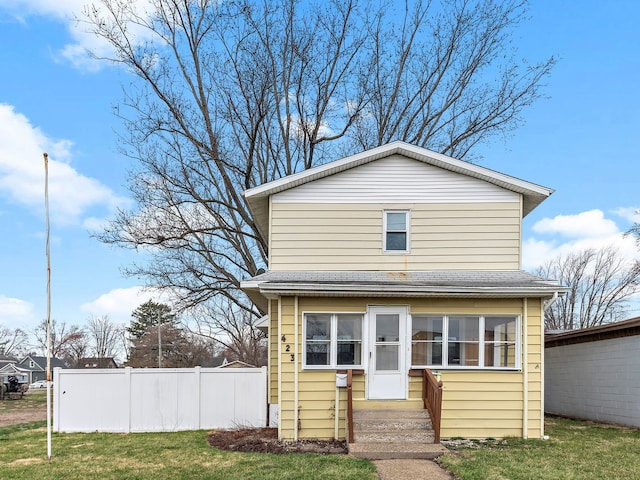 view of front of house with a front lawn and fence