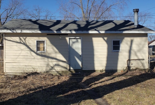 rear view of property featuring a shingled roof