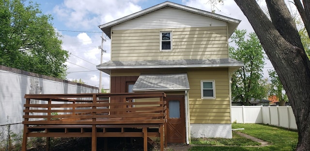 rear view of property featuring a wooden deck and fence
