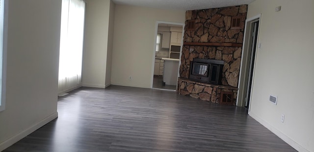 unfurnished living room featuring baseboards, dark wood-type flooring, and visible vents