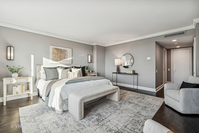 bedroom with dark wood-style floors, visible vents, ornamental molding, and baseboards