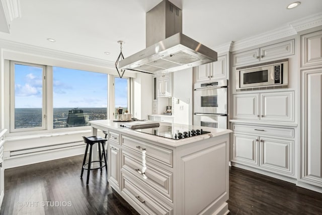 kitchen featuring island range hood, a kitchen island, appliances with stainless steel finishes, light countertops, and a baseboard heating unit