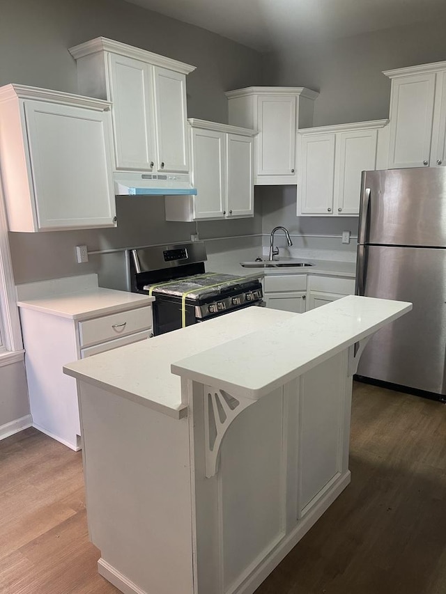 kitchen featuring a kitchen island, appliances with stainless steel finishes, under cabinet range hood, white cabinetry, and a sink