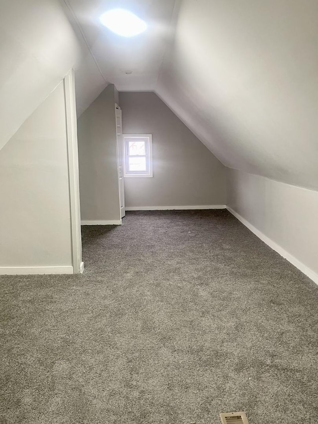 additional living space with vaulted ceiling, carpet floors, and baseboards