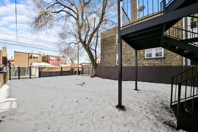 yard covered in snow featuring fence