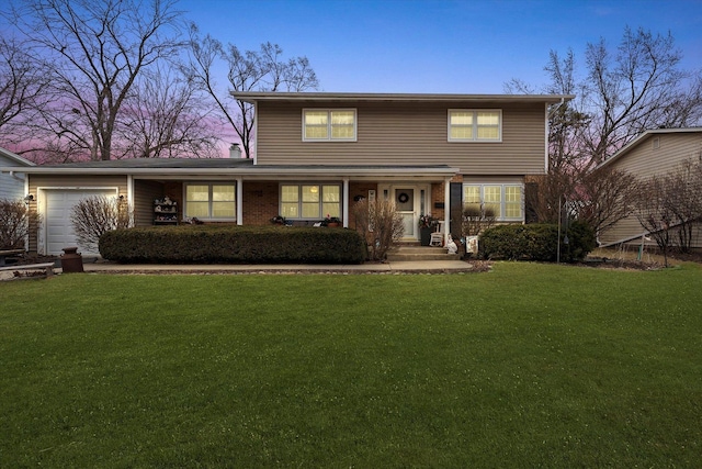 traditional-style home with a garage, a yard, and brick siding